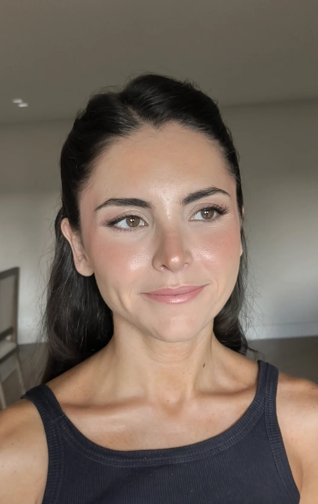 The godmother in the morning, freshly made up and styled, with luminous skin, soft blush and her hair swept back