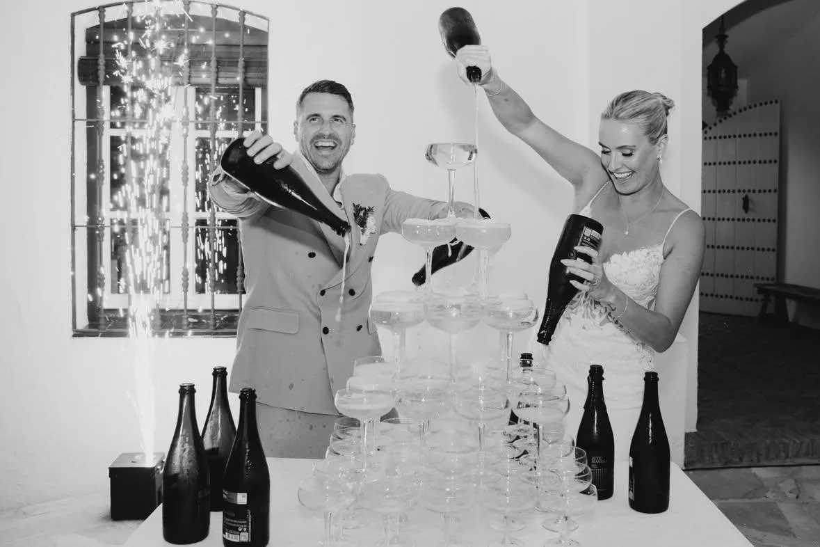 Los novios sirven una torre de copas de cava en el Cortijo Pedro Jiménez, en Casares