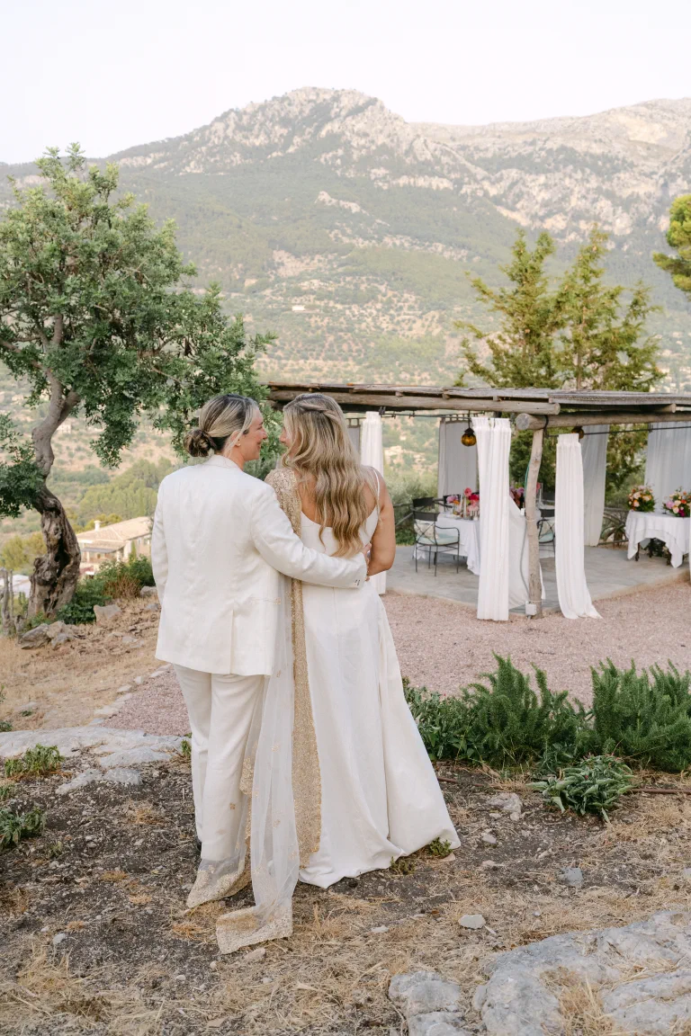 The two brides embracing in front of the Tramuntana mountains