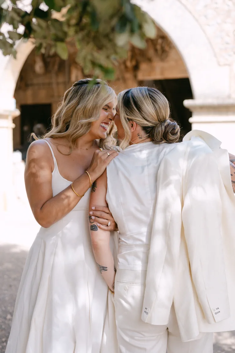 Ashton laughs with romantic waves as Jordan, seen from behind, shows her polished low updo