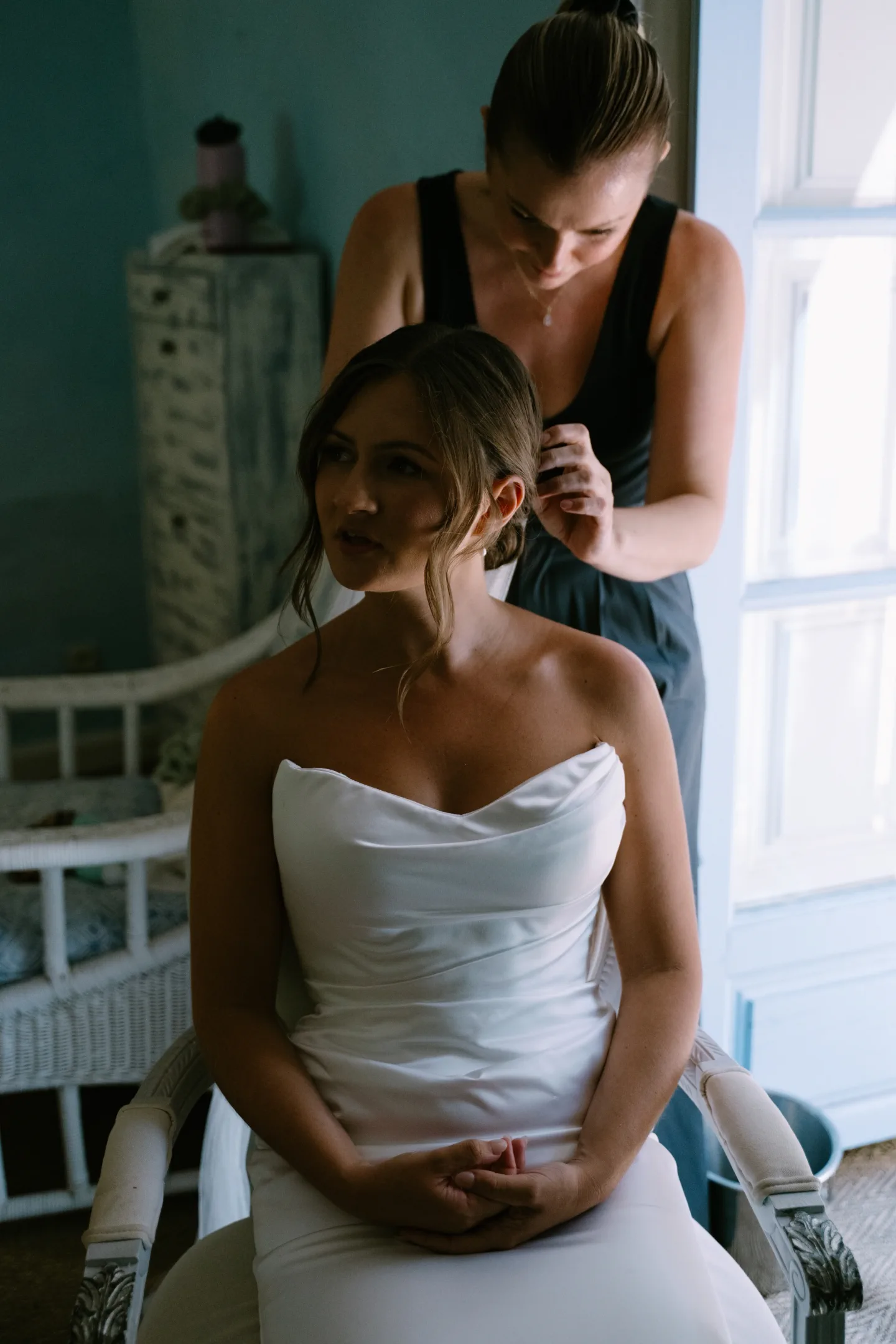 Finishing touches to the bride's low updo while she gets ready