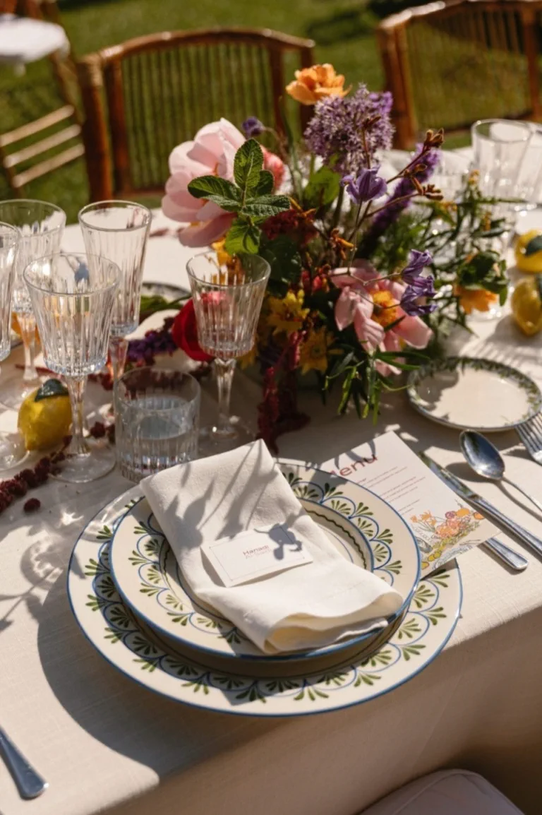 A wild-looking flower centrepiece, green-bordered ceramic plates and lemons on the tablecloth