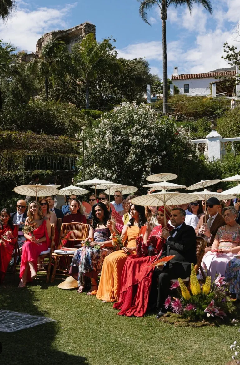 Guests seated under parasols during the garden ceremony at Torre de Tramores