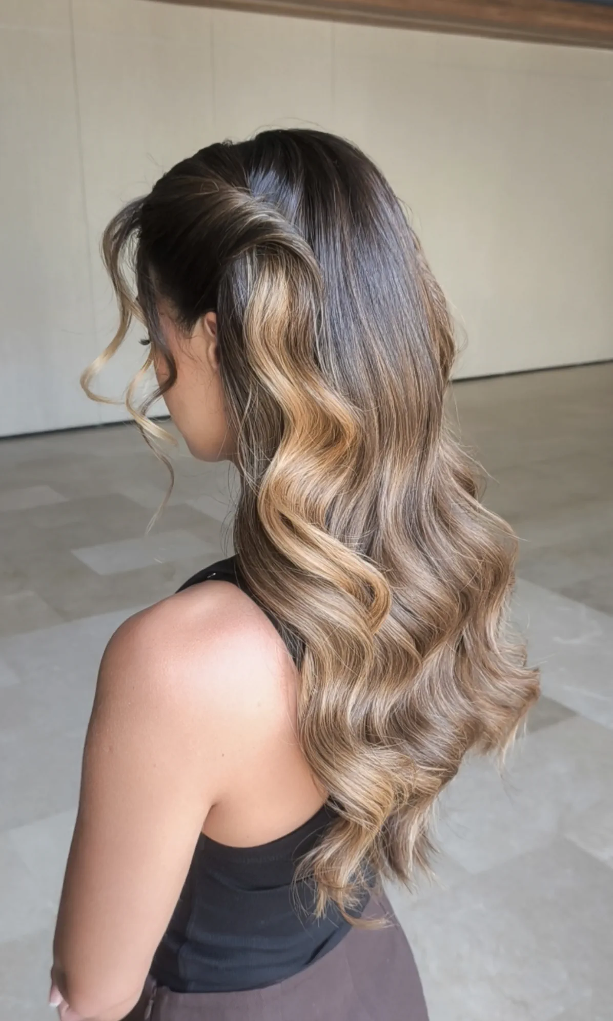 Long hair in defined waves with a side parting, seen from behind