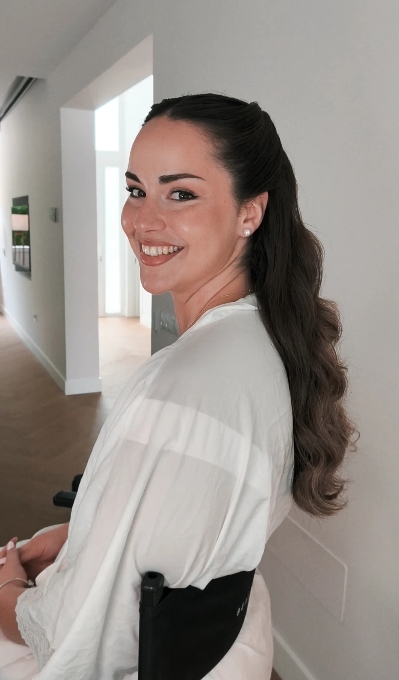 Half-up hair with long waves, in profile and smiling